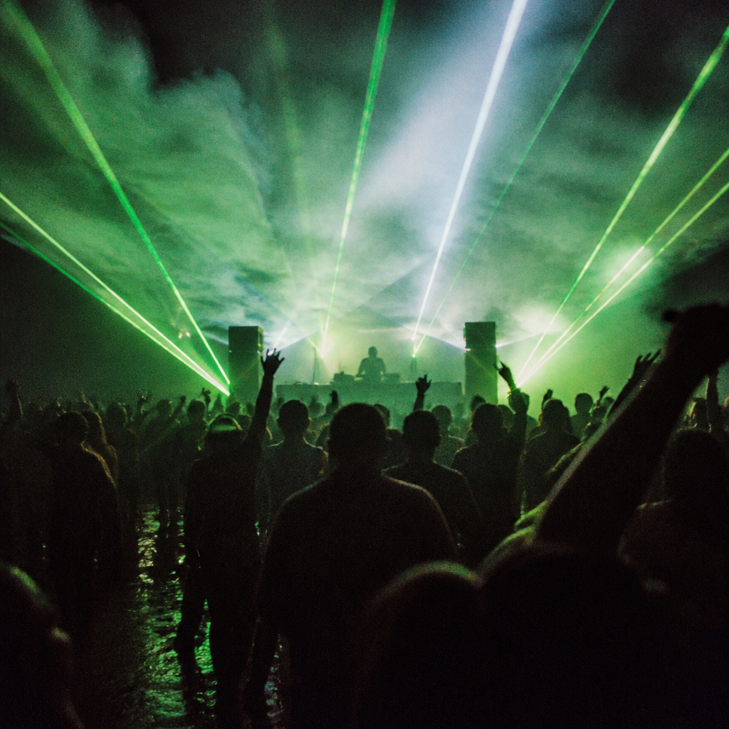 Green laser beams cutting through thick smoke above a crowd on the deck at night